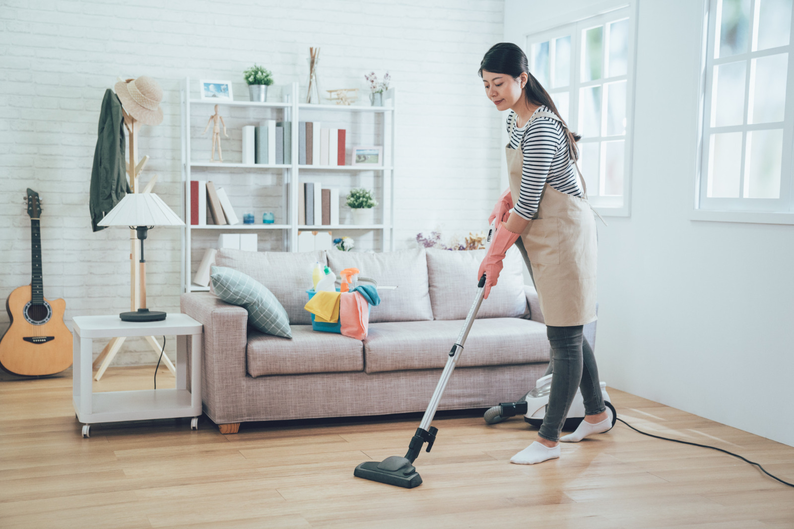 Wood Floor Waxing in Chelsea on engineered oak hardwood floorboards—homeowner vacuuming the living room as gentle aftercare to preserve the satin wax sheen.