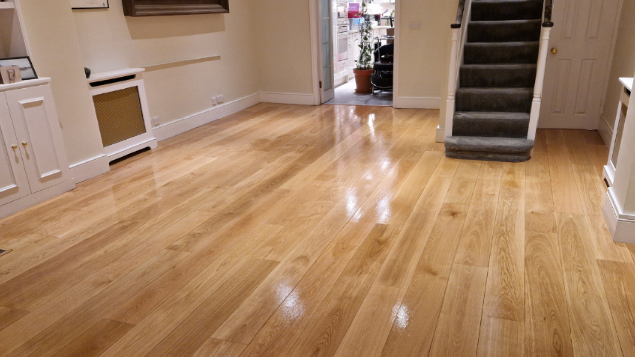 Wood Floor Waxing in Chelsea on European oak hardwood floorboards (solid oak planks) in a living room with staircase, showing a freshly buffed glossy finish and clear grain.